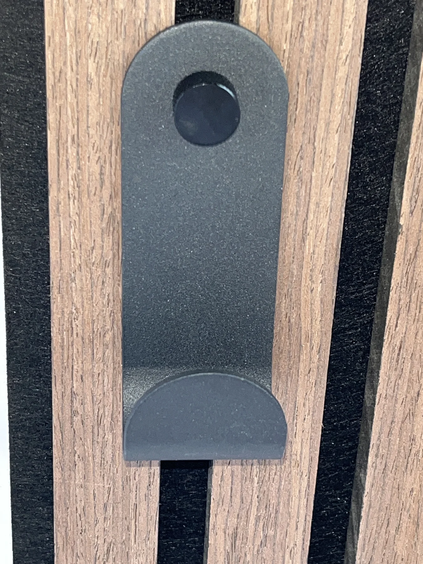 Front photograph of a single curved hook on a sample panel