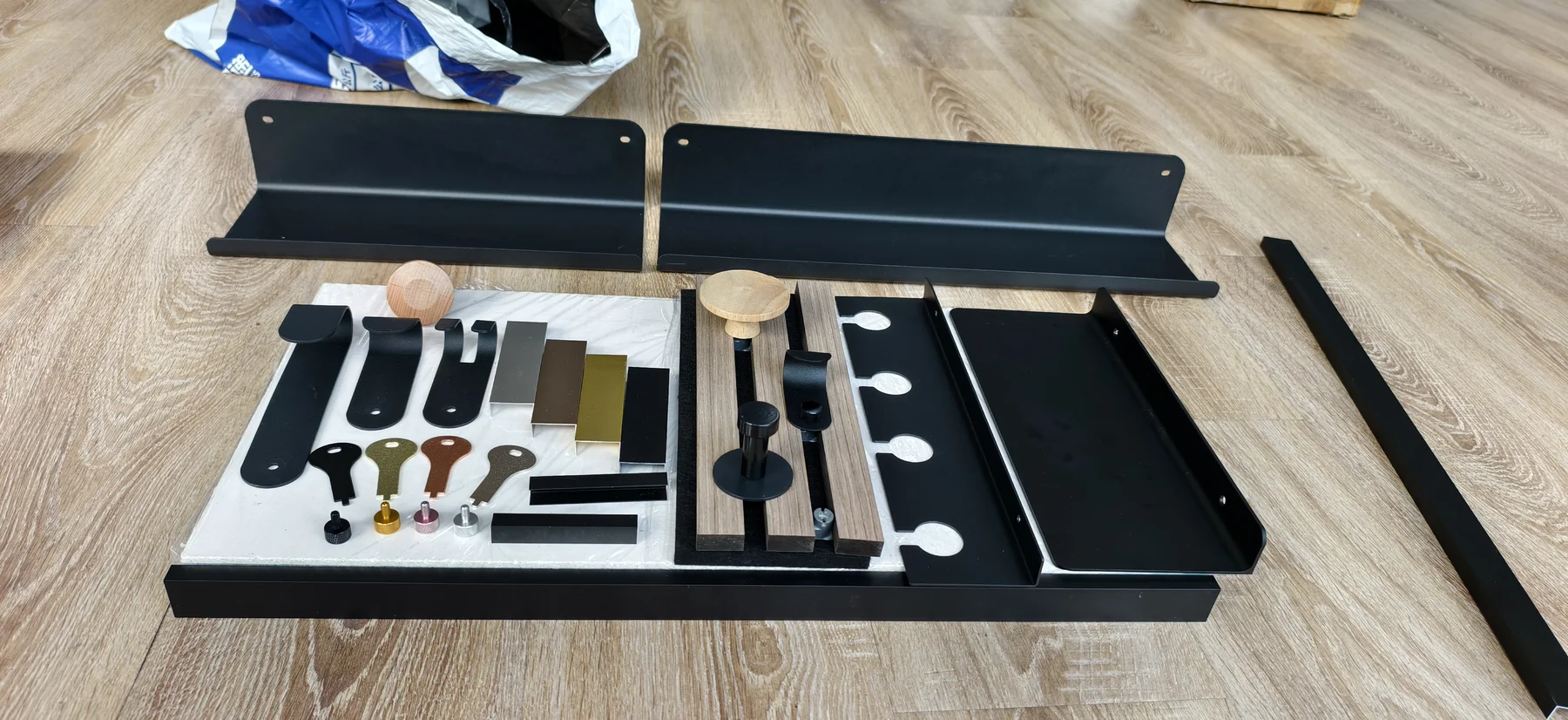 Black PET slatwall hooks and shelf accessories arranged as a system